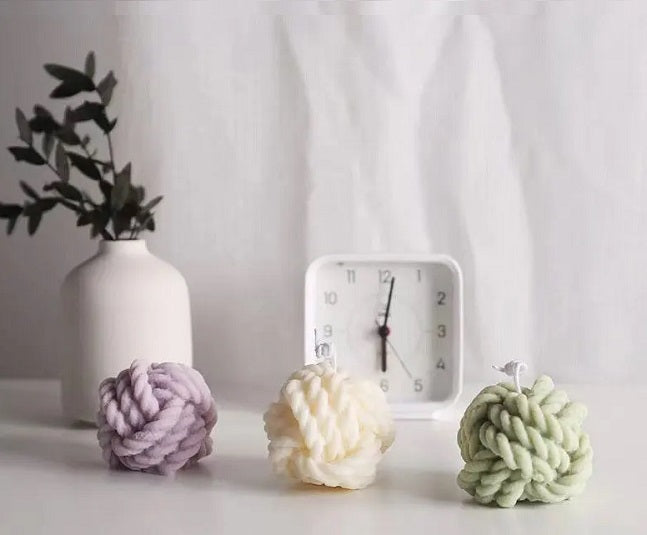 Stylische Kerze im Wollknäuel-Knoten-Design